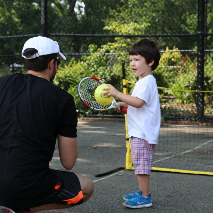 Child taking tennis lesson