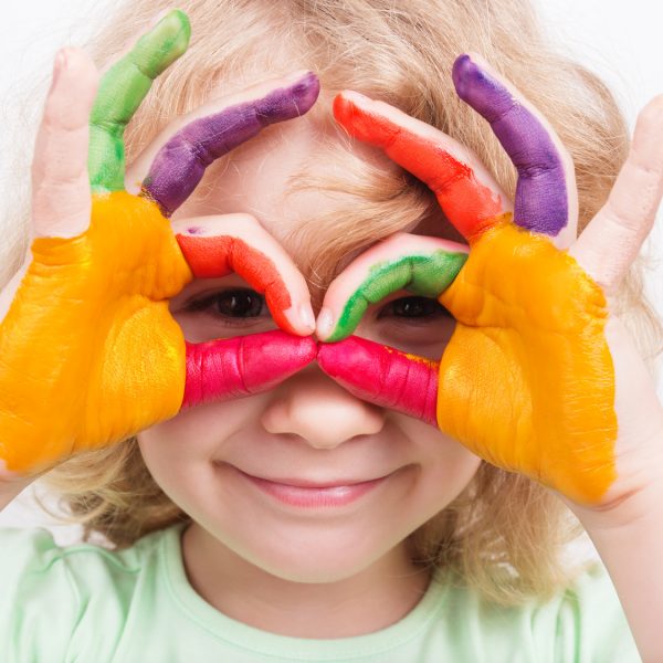 Little girl hands painted in colorful paints